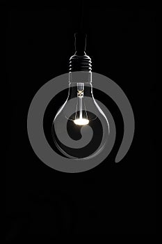 Glowing electric light bulb, black background