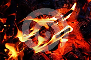 Glowing embers in hot red color, abstract background. The hot embers of burning wood log fire. Firewood burning on grill