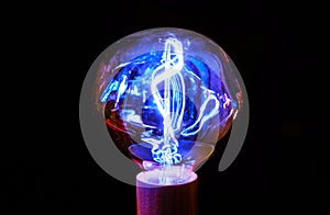 Glowing fancy tungsten filament light bulb.