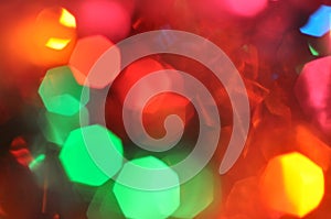 Glowing and festive colored light circles created from in camera and lens bokeh. Christmas fairy lights defocused giving a blurred