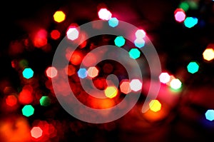 Glowing and festive colored light circles created from in camera and lens bokeh. Christmas fairy lights defocused giving a blurred