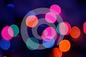 Glowing and festive colored light circles created from in camera and lens bokeh. Christmas fairy lights defocused giving a blurred