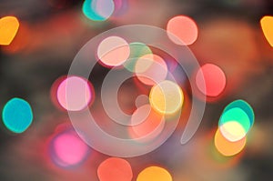 Glowing and festive colored light circles created from in camera and lens bokeh. Christmas fairy lights defocused giving a blurred