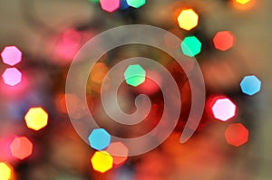 Glowing and festive colored light circles created from in camera and lens bokeh. Christmas fairy lights defocused giving a blurred