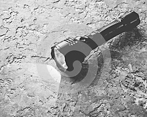 A glowing flashlight on a gray concrete table