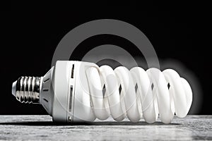 Glowing fluorescent bulb light on the grey table on black background