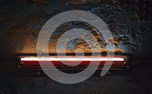 Glowing fluorescent lamp in an old rusty red shade. Highlights a beautifully crumbling blue concrete wall.