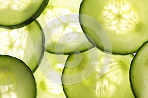 Glowing green cucumber slices background