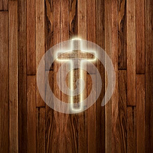 Glowing holy cross on wooden background