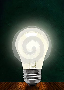 Glowing Incandescent Light Bulb Isolated on Chalkboard Background