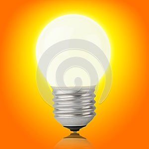 Glowing incandescent light bulb on yellow-orange photo