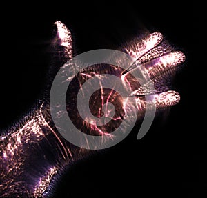 Glowing kirlian coronal aura photography with blue and purple colors of a male human hand