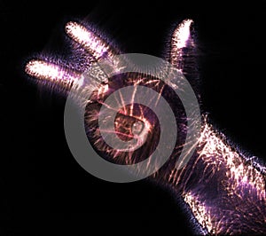 Glowing kirlian coronal aura photography with blue and purple colors of a male human hand