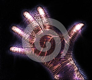 Glowing kirlian coronal aura photography with blue and purple colors of a male human hand photo