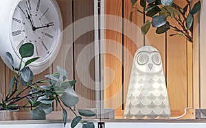 Glowing lamp in the shape of an owl on a wooden shelf