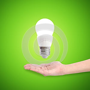 Glowing LED energy saving bulb in a hand.