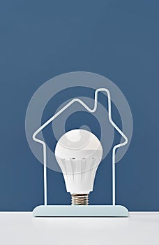 Glowing LED light bulb on blue background. Energy efficient saving