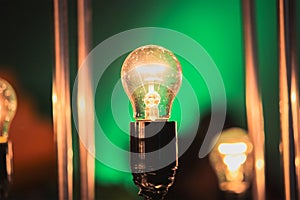 glowing light bulb against green wall background