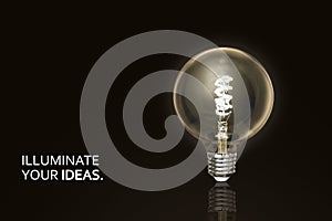 Glowing light bulb on dark background with text. Concept of creativity, idea.