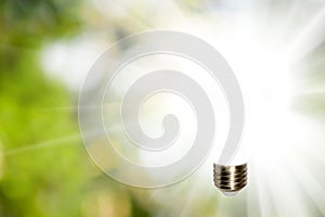 glowing light bulb on a green blurred background. The concept of the source of knowledge, ideas and reason