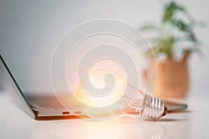 Glowing light bulb with laptop background. Self learning or education knowledge and business studying concept. Idea of learning