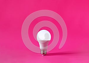 Glowing light bulb on magenta background. Discovery, invention, new idea concept