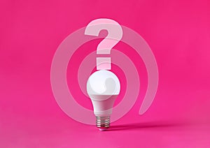 Glowing light bulb with question mark on top of it on magenta background. Question, searching for ideas concept