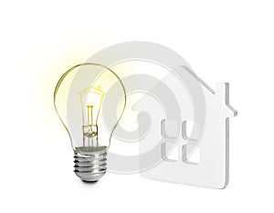 Glowing light bulb and small model of house on background. Energy efficiency, loan, property or business idea concepts