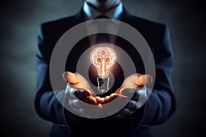 Glowing light bulb with smart brain inside on businessman hands, brainstorming new ideas with creativity and innovation technology