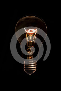 Glowing light bulb without wires on black background