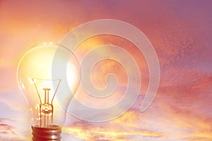 Glowing lightbulb in sky