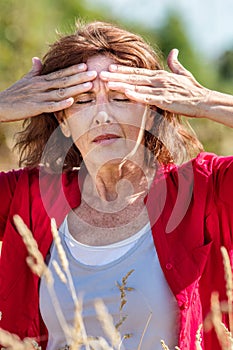 Glowing middle aged woman with freckles suffering from headache