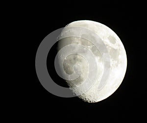 A glowing moon on a black night sky at the beginning of spring.