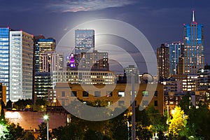 Glowing Moon Rises Behind The Denver Skyline photo