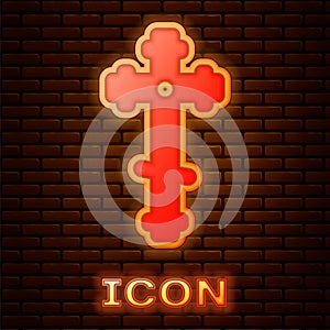 Glowing neon Christian cross icon isolated on brick wall background. Church cross. Vector