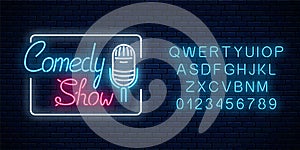 Glowing neon comedy show sign with retro microphone in rectangle frame with alphabet. Humor monolog signboard