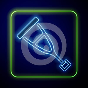 Glowing neon Crutch or crutches icon isolated on blue background. Equipment for rehabilitation of people with diseases