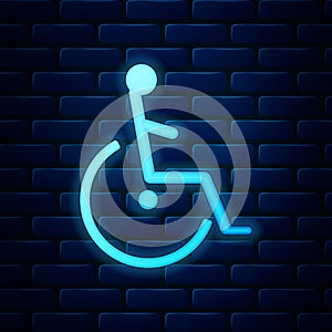 Glowing neon Disabled handicap icon isolated on brick wall background. Wheelchair handicap sign