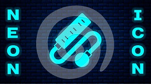 Glowing neon Electric extension cord icon isolated on brick wall background. Power plug socket. Vector