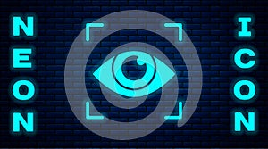 Glowing neon Eye scan icon isolated on brick wall background. Scanning eye. Security check symbol. Cyber eye sign