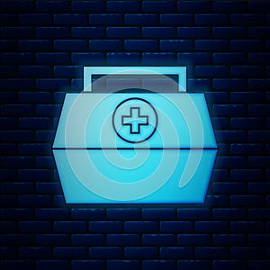 Glowing neon First aid kit icon isolated on brick wall background. Medical box with cross. Medical equipment for