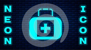 Glowing neon First aid kit icon isolated on brick wall background. Medical box with cross. Medical equipment for