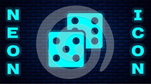 Glowing neon Game dice icon isolated on brick wall background. Casino gambling. Vector