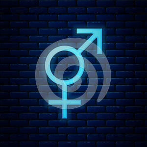 Glowing neon Gender icon isolated on brick wall background. Symbols of men and women. Sex symbol