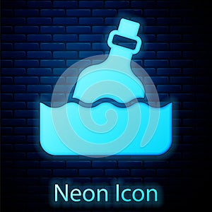 Glowing neon Glass bottle with a message in water icon isolated on brick wall background. Letter in the bottle. Pirates