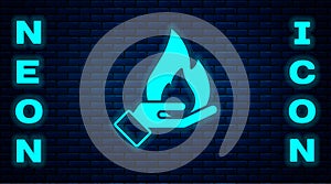 Glowing neon Hand holding a fire icon isolated on brick wall background. Insurance concept. Security, safety, protection