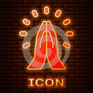 Glowing neon Hands in praying position icon isolated on brick wall background. Prayer to god with faith and hope. Vector