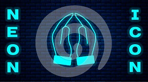 Glowing neon Hands in praying position icon isolated on brick wall background. Prayer to god with faith and hope. Vector