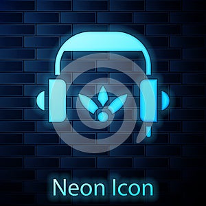 Glowing neon Headphones for meditation icon isolated on brick wall background. Vector