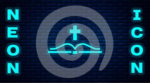 Glowing neon Holy bible book icon isolated on brick wall background. Vector